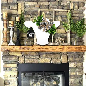 Décoration de porte tête de vache avec nœud à carreaux sur une cheminée rustique