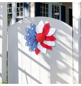 Patriotic mesh wreath with American flag design displayed on a white garden gate