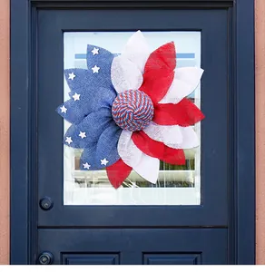 Patriotic red white and blue flower wreath decoration hanging on a blue front door.