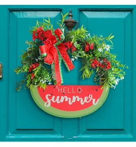 Decorative summer watermelon wreath with Hello Summer sign hanging on a teal door