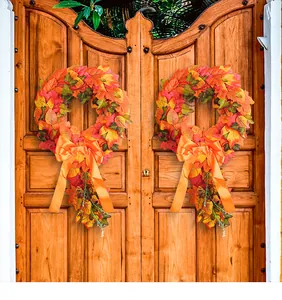 Candy cane autumn wreath with faux maple leaves and orange bow for harvest decor.