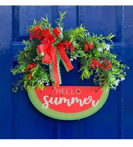 Detail view of a vibrant watermelon themed door wreath with a Hello Summer wooden sign