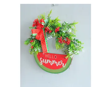 Detailed view of a summer wreath featuring a watermelon bow and a Hello Summer sign