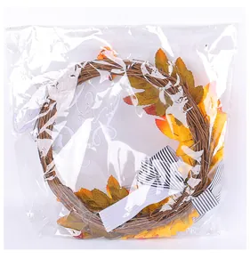 Detailed view of autumn harvest wreath with maple leaves in clear plastic packaging