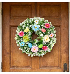 Easter wreath with colorful speckled eggs and flowers hanging on a rustic wooden door.