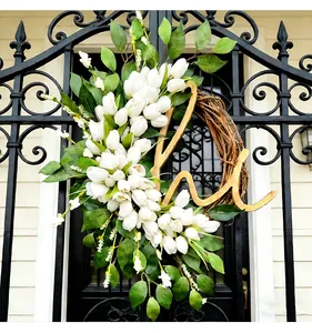 Eleganter Frühlingskranz mit weißen Tulpen und Holzbuchstaben M an einem schwarzen Tor