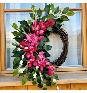 Nahaufnahme eines Frühlings-Tulpenkranzes mit rosa Blüten und grünen Blättern am Fenster.