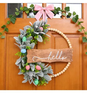 Detailed view of handmade Easter wreath with 'hello' wooden sign and colorful speckled eggs