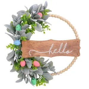 Decorative spring Easter wreath with lamb's ear leaves, colored eggs, and wooden hello sign