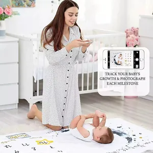 Maman photographiant bébé sur une couverture étape en flanelle avec motif de lune et étoiles