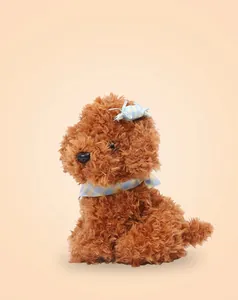 Detalle de peluche de caniche marrón con pelo rizado suave y pajarita azul decorativa