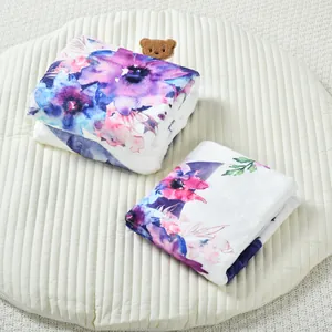 Détail d'une couverture de jalon bébé en flanelle à fleurs sur un tapis blanc