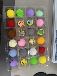 Détail montrant une variété de jouets spongieux colorés en forme de raviolis dans un plateau.