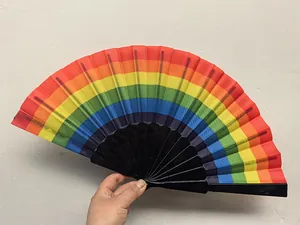 Λεπτομερές κοντινό πλάνο πολύχρωμης βεντάλιας ουράνιου τόξου στο χέρι σε λευκό τοίχο