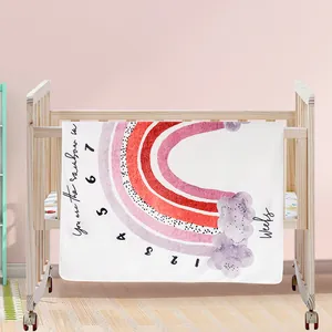 Vue détaillée d'une couverture d'étape pour bébé avec arc-en-ciel sur un berceau