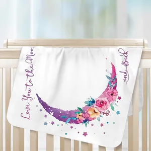 Couverture en flanelle pour bébé avec motif de lune fleurie sur un berceau en bois clair.