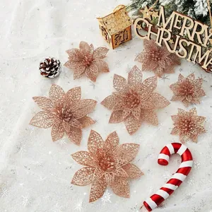 Flores de nochebuena con purpurina oro rosa en un detalle festivo de Navidad