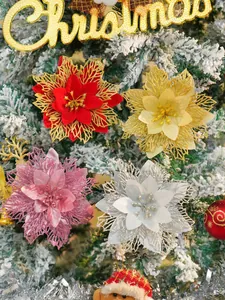Primer plano de flores de nochebuena con purpurina decorando un árbol de Navidad nevado