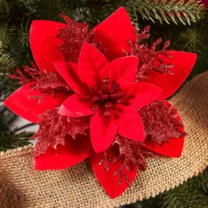 Close-up of red glitter artificial poinsettia flower on a Christmas tree branch