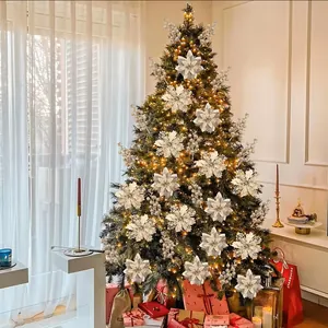 Elegant white artificial poinsettia flowers and snowflakes on a decorated Christmas tree
