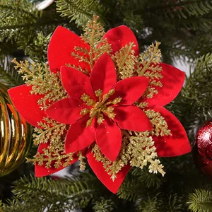 Close-up of a decorative red velvet Christmas poinsettia with elegant gold glitter