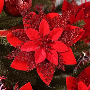 Detailed view of a vibrant red glitter artificial poinsettia flower on a Christmas tree