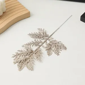 Detailweergave van een champagnegouden glitter kunstdennentak voor DIY kerstversiering