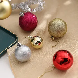 Detail of festive Christmas baubles with glitter and metallic finishes on neutral fabric