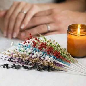 Nahaufnahme von glitzernden bunten Kunstbeeren für die festliche Weihnachts-DIY-Deko