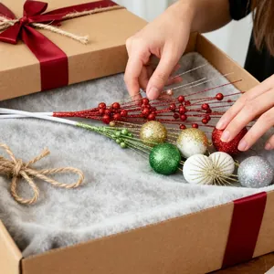 Detailansicht von glitzernden Weihnachtszweigen und Deko-Kugeln in einer Geschenkbox.