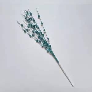 Close-up of turquoise glitter artificial berry stem for festive Christmas DIY decoration