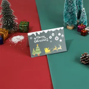 Détail d'une carte de vœux de Noël grise avec le traîneau du Père Noël et des sapins