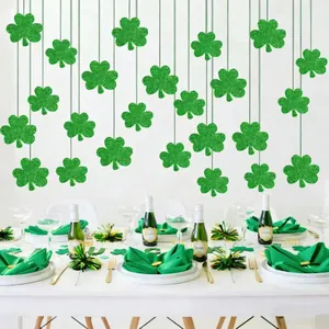 Green glitter shamrock garlands hanging over a St. Patrick's Day themed dining table setup