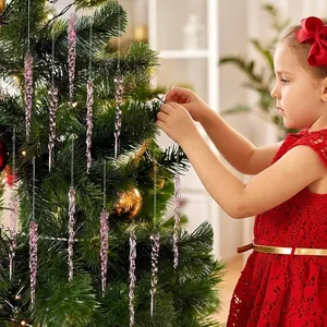 Gros plan de décorations de glaçons en acrylique rose sur un sapin de Noël avec un enfant