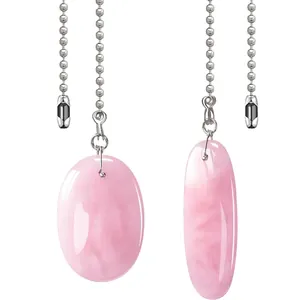 Gros plan de pendentifs ovales en quartz rose avec chaînes à billes argentées
