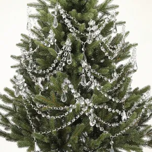 Detailweergave van kristallen kralenslingers en ijspegelhangers aan een groene kerstboom