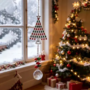 Vista detallada de un atrapasol de árbol de Navidad con gemas rojas y bola de cristal