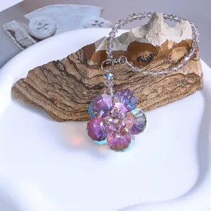 Gros plan d'un attrape-soleil en fleur de cristal irisé avec chaîne en perles