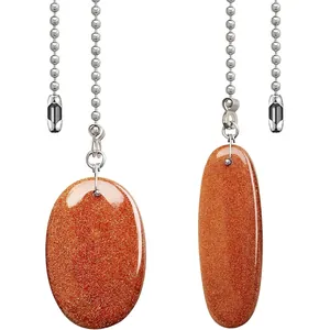 Détail de pendentifs ovales en pierre de soleil avec chaînes à billes pour ventilateurs.