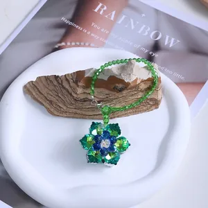 Detail view of green crystal flower suncatcher for home and car decor.