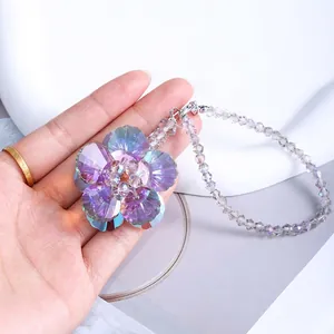 Gros plan d'un attrape-soleil en fleur de cristal avec des pétales violets irisés.
