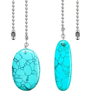 Détail des chaînes de ventilateur de plafond avec pendentifs ovales en turquoise.