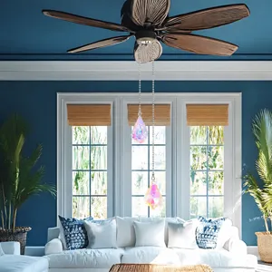 Due pendenti acchiappasole in cristallo iridescente appesi a un ventilatore da soffitto marrone