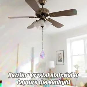 Regenboog kristallen suncatcher hanger hangend aan een plafondventilator ketting.
