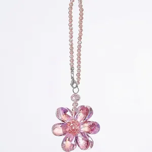 Macro detail of a pink faceted crystal flower suncatcher showing prismatic light effects