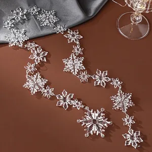 Elegant clear acrylic snowflake ornaments arranged on a warm terracotta background