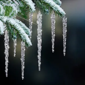 Detalle de adornos de carámbanos de cristal colgados en una rama de árbol de Navidad nevada