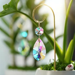 Detailed view of an iridescent teardrop crystal suncatcher hanging as plant decoration