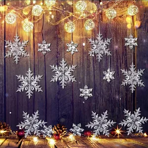 Transparent snowflake ornaments hanging on wooden background with warm lights