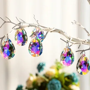 Detailed macro view of AB coated teardrop crystal suncatcher hanging on a branch